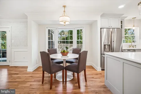 a view of kitchen with stainless steel appliances wooden floor and chair