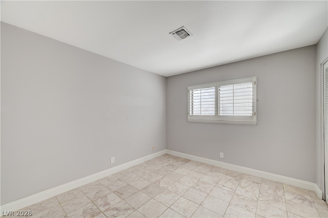6635 Costa Brava Road Las Vegas, NV 89146 - Photo 37 of 59 A well-lit bedroom featuring durable tile flooring and natural light through window shutters.
