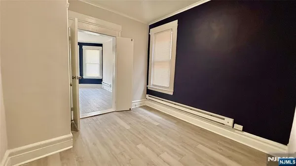 an empty room with wooden floor and closet