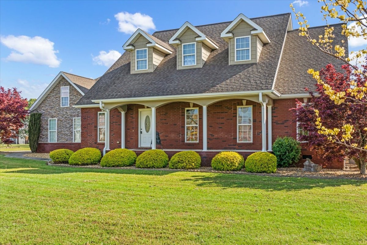 a brick house with garden in front of it