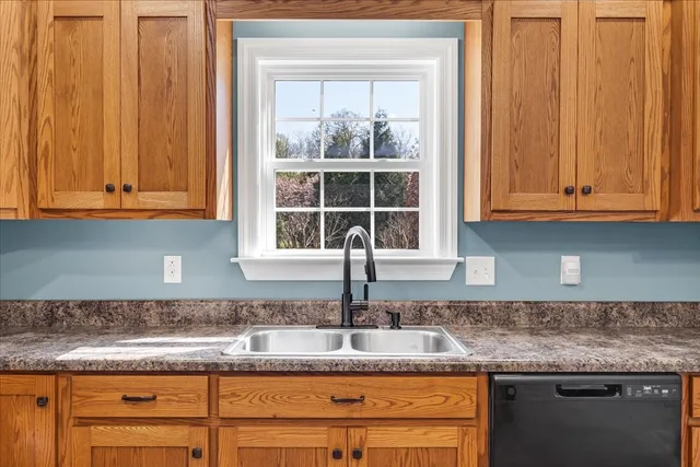 a kitchen with granite countertop cabinets sink and window