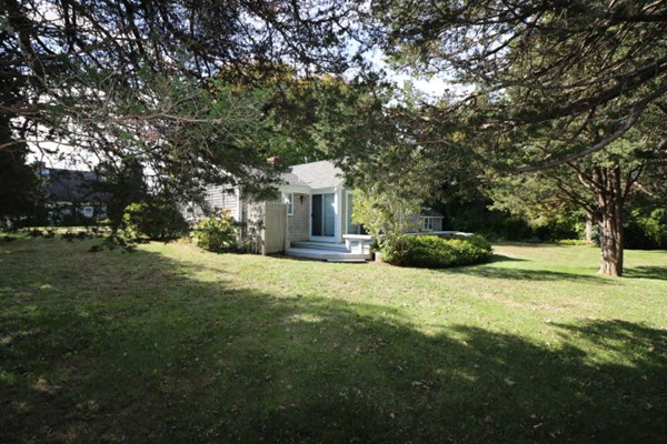 24 Mill Pond Road Orleans, MA 02653 - Photo 16 of 25 a front view of a house with a yard and trees