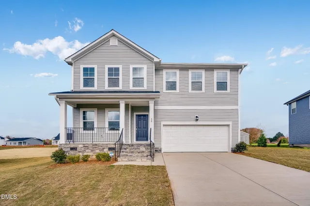 a front view of a house with a yard and garage