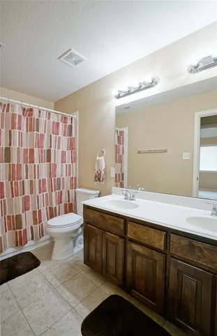 a bathroom with a double vanity sink toilet and shower