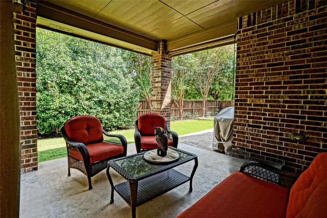 a view of a house with a small yard and a large tree