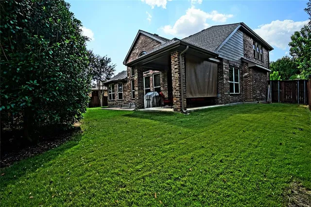 a view of a house with backyard and sitting area