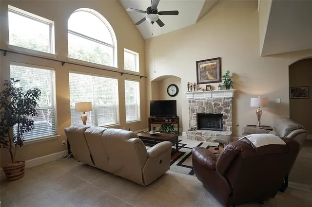 a living room with furniture a fireplace and a large window