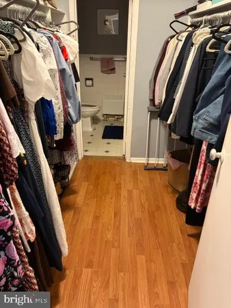 a view of walk in closet with clothes and shoes