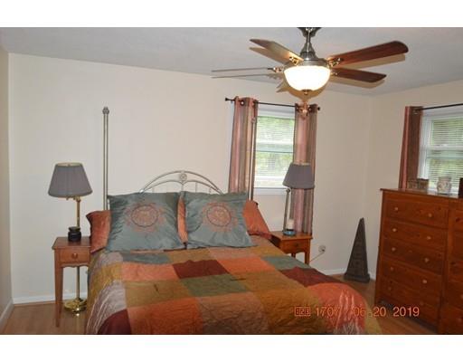 651 Sterling Road Lancaster, MA 01523 - Photo 8 of 12 a bedroom with a bed and a chandelier