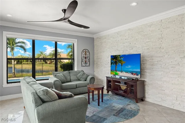 a living room with furniture a floor to ceiling window and a flat screen tv