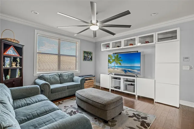 a living room with furniture a flat screen tv and a window