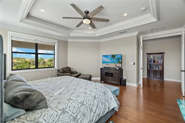 a bedroom with a bed and a large window with wooden floor