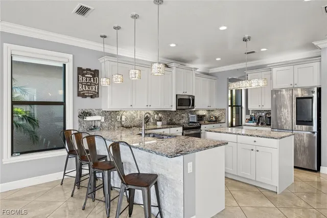 a kitchen with stainless steel appliances kitchen island granite countertop a sink and cabinets