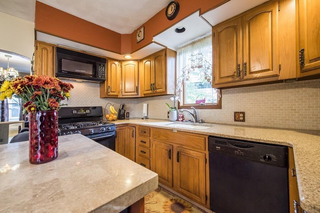 46 Parkside Street Springfield, MA 01104 - Photo 4 of 23 a kitchen with stainless steel appliances granite countertop a sink dishwasher stove and cabinets with wooden floor