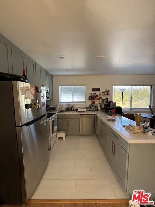 1724 Broadway Street Oceanside, CA 92054 - Photo 6 of 19 a kitchen with a refrigerator a sink dishwasher a stove top oven a refrigerator and cabinets