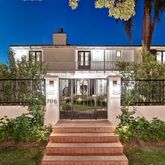 a view of a house with a small yard and potted plants