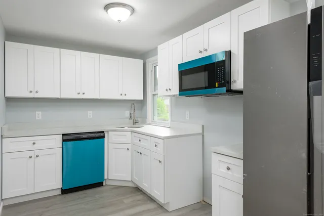 a kitchen with white cabinets stainless steel appliances and sink