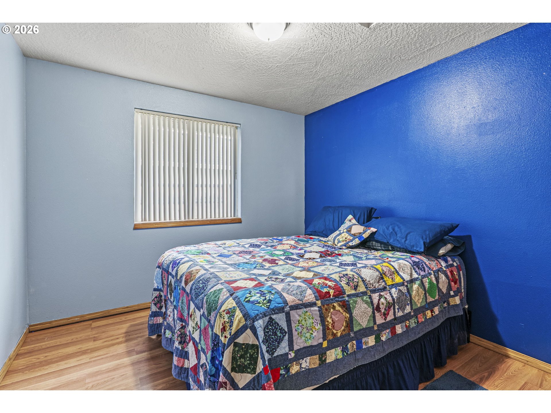 1102 South 11th Avenue Kelso, WA 98626 - Photo 17 of 32 a bedroom with a bed a dresser with wooden floor