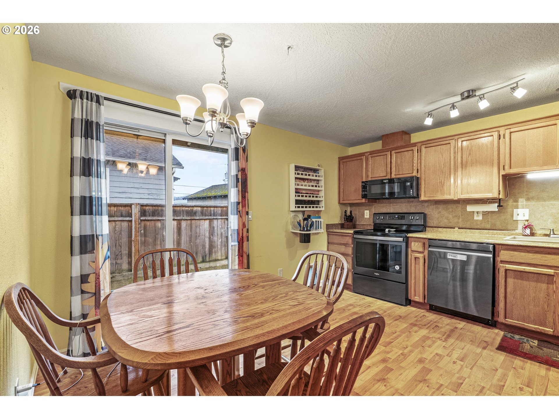 1102 South 11th Avenue Kelso, WA 98626 - Photo 9 of 32 a dining room with stainless steel appliances kitchen island granite countertop a stove a kitchen island a dining table and chairs
