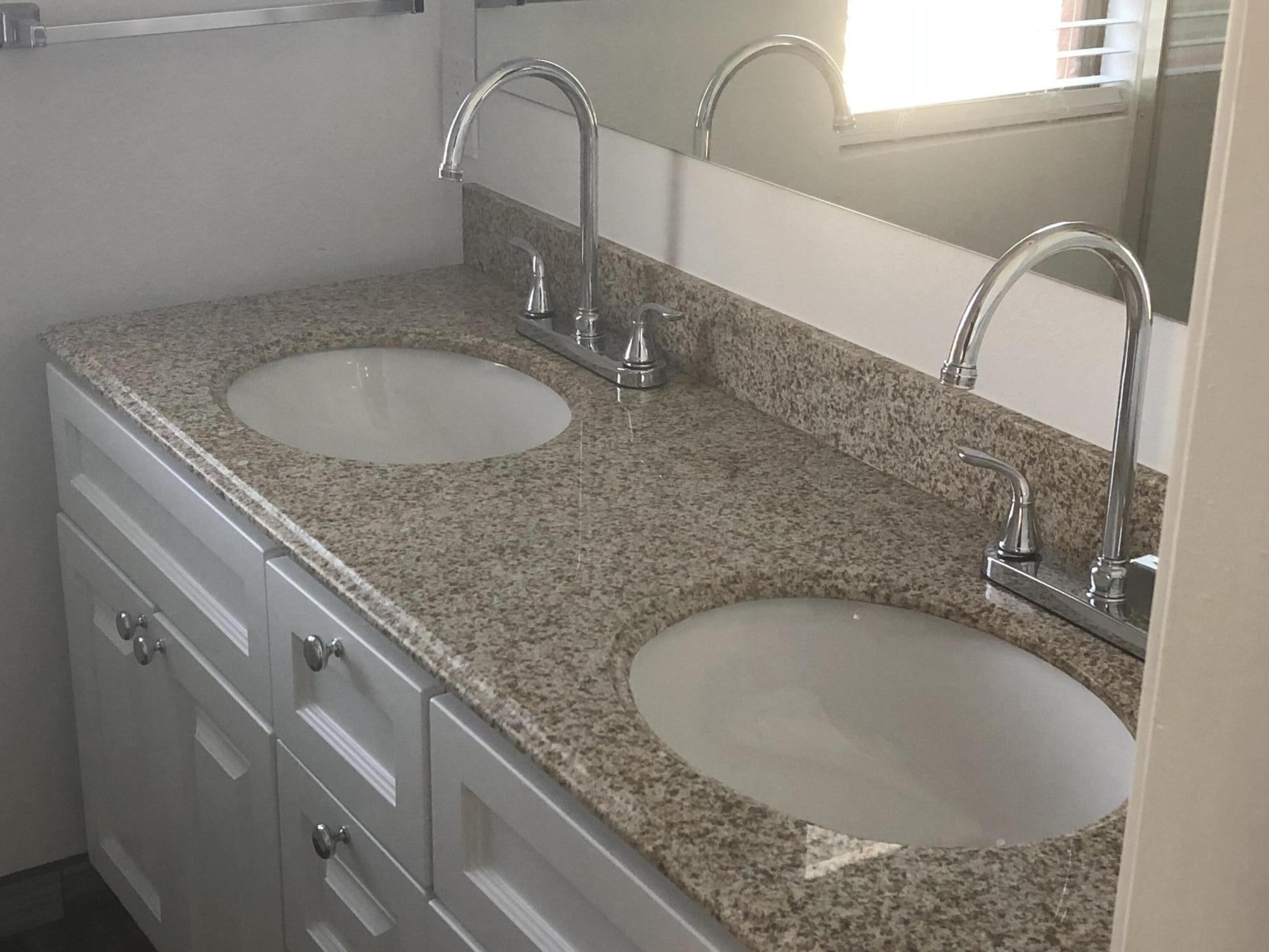 809 Bath Street, Unit 811 Santa Barbara, CA 93101 - Photo 6 of 13 a bathroom with a granite countertop sink a mirror and vanity