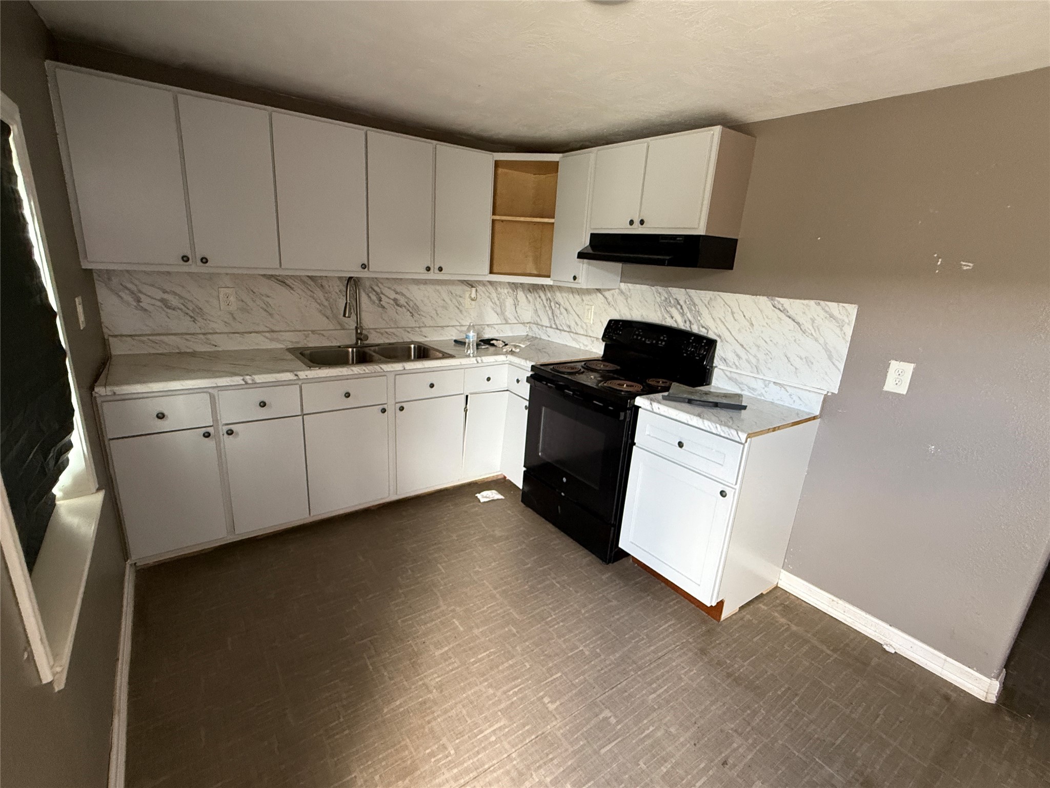 4011-4017 Terry Street Houston, TX 77009 - Photo 26 of 48 a kitchen with granite countertop white cabinets sink and stainless steel appliances