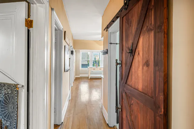 a view of a hallway with wooden floor and staircase