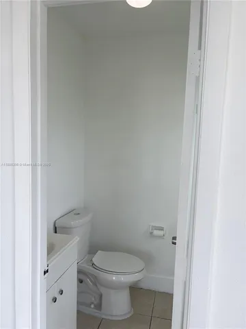a white toilet sitting next to a white cabinet