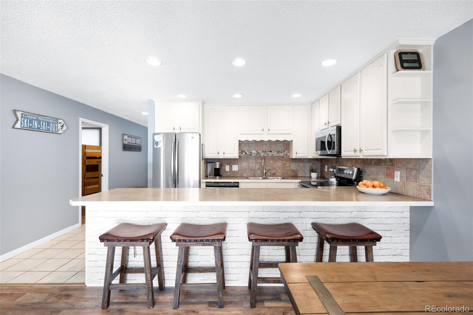 760 Copper Road, Unit F204 Frisco, CO 80443 - Photo 5 of 30 a kitchen with stainless steel appliances kitchen island granite countertop a table chairs sink and cabinets