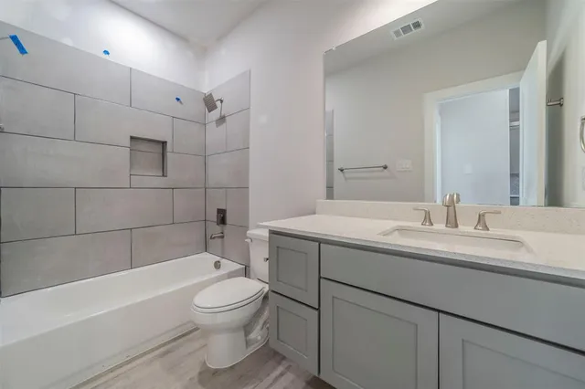 a bathroom with a granite countertop sink a toilet and bathtub