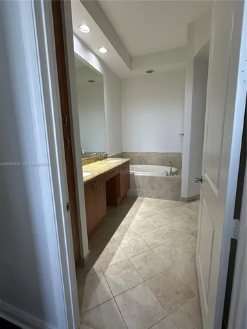 a bathroom with a tub sink and mirror