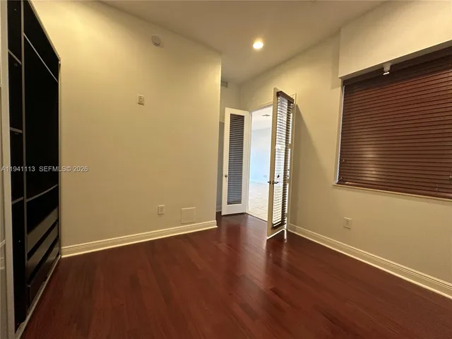 an empty room with wooden floor and a window