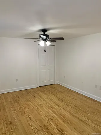 a view of an empty room with a chandelier fan