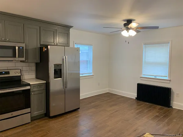 a kitchen with granite countertop a refrigerator and a stove top oven