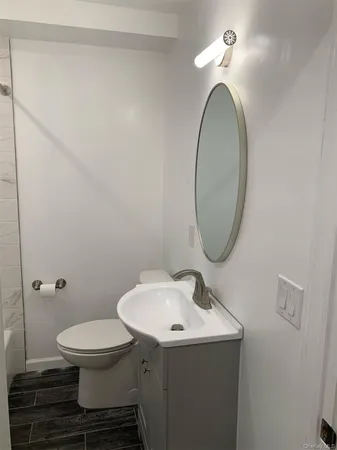 a bathroom with a toilet sink and mirror