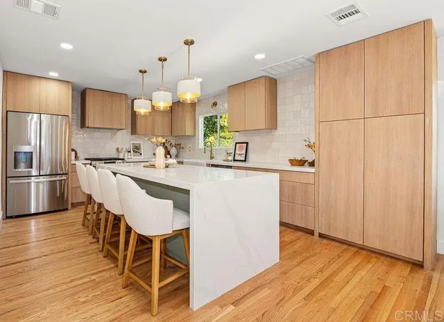 a kitchen with kitchen island granite countertop a sink a counter space appliances and cabinets