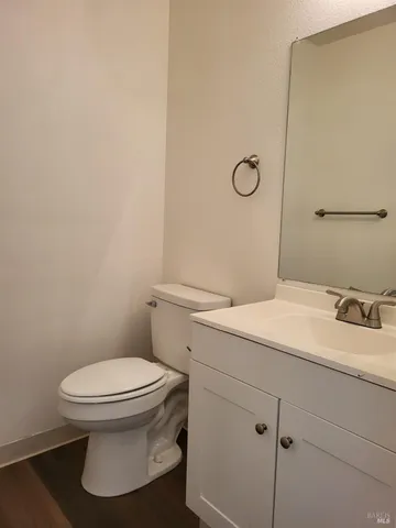 a bathroom with a granite countertop toilet and a sink