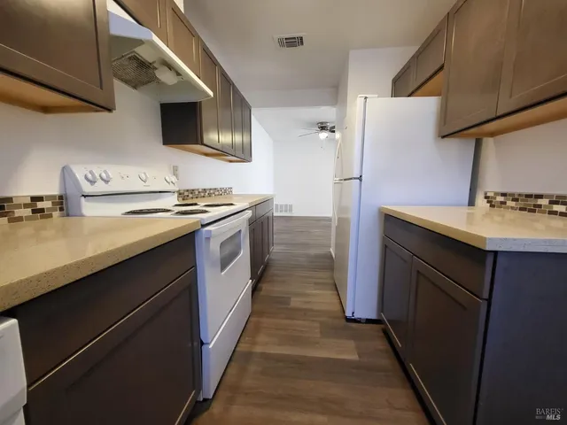 a kitchen with stainless steel appliances granite countertop a stove a sink and a refrigerator