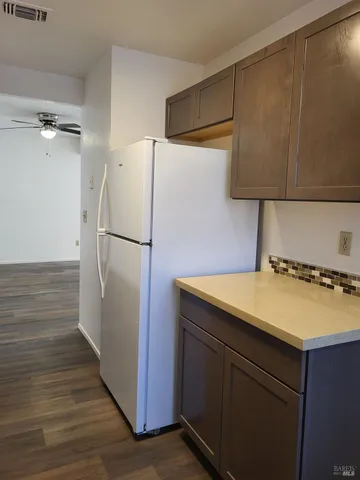 a kitchen with a refrigerator and a stove top oven