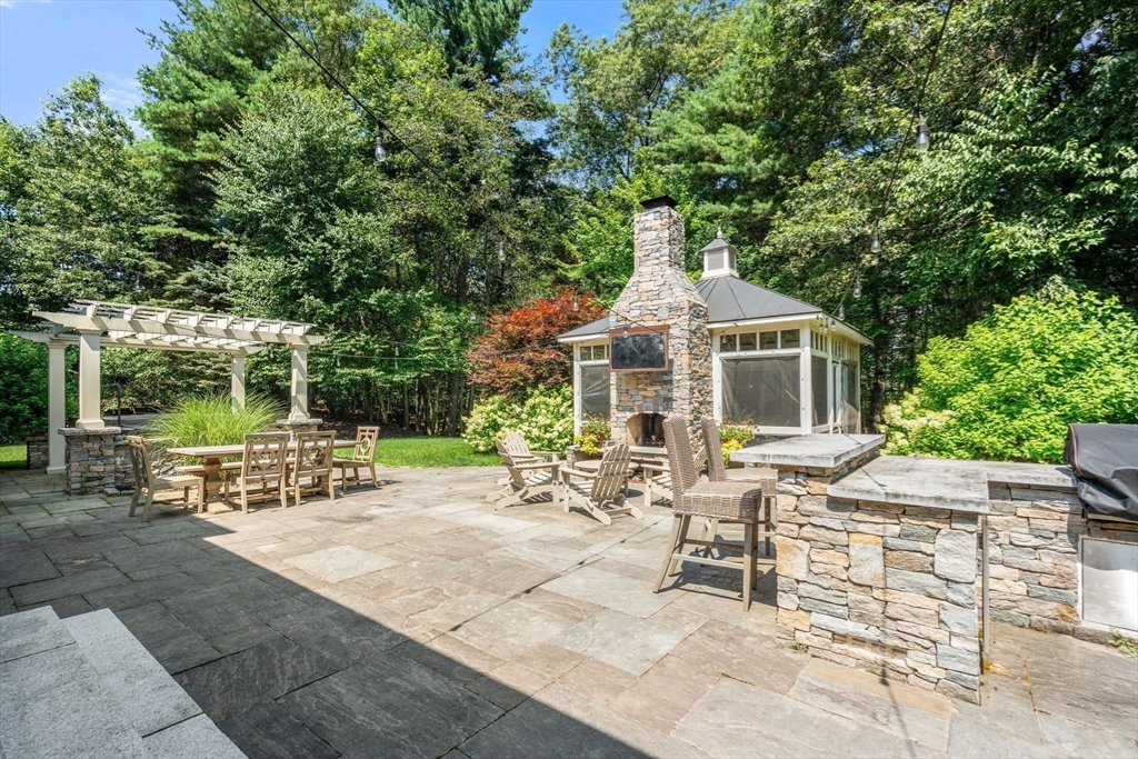 114 Fox Run Road Bolton, MA 01740 - Photo 30 of 37 a view of a patio with table and chairs under an umbrella