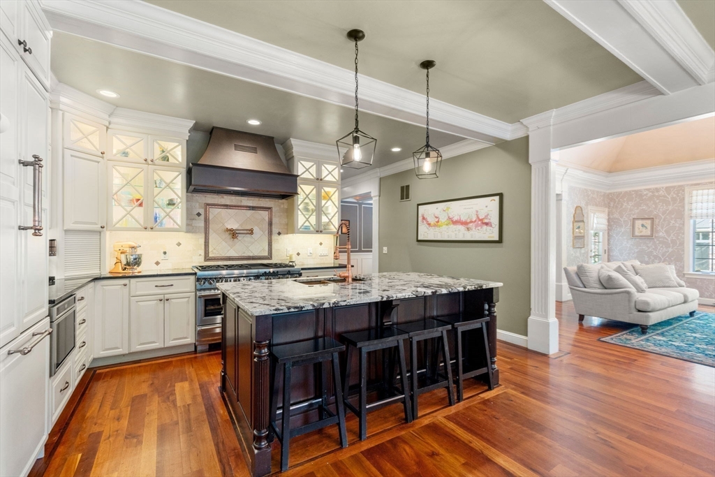 114 Fox Run Road Bolton, MA 01740 - Photo 8 of 37 a kitchen with a stove a refrigerator a sink dishwasher with a dining table and chairs with wooden floor