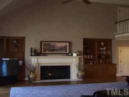 1021 Quiet Ridge Circle Raleigh, NC 27614 - Photo 9 of 9 a living room with furniture a fireplace and a flat screen tv
