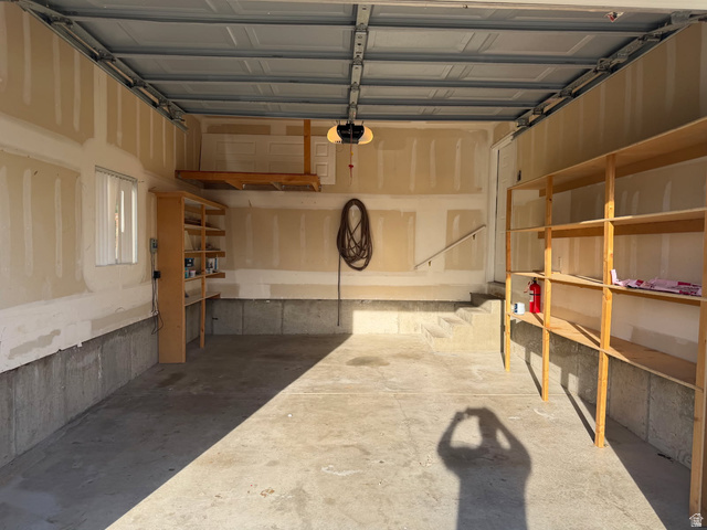 1563 South 600 East Springville, UT 84663 - Photo 28 of 30 Spacious garage featuring a concrete floor, built-in shelving, an overhead storage platform, a window, and an automatic garage door opener