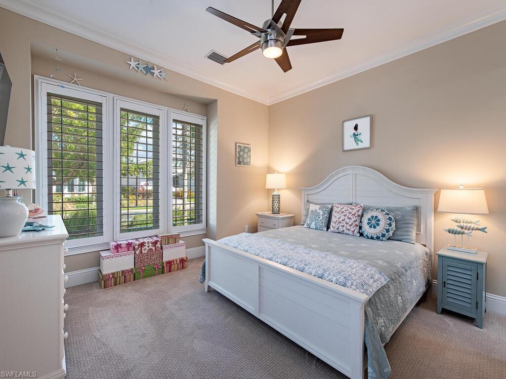 6445 Pembroke Way Naples, FL 34113 - Photo 17 of 40 a bedroom with a bed couch and a large window