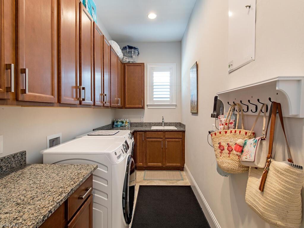 6445 Pembroke Way Naples, FL 34113 - Photo 18 of 40 a kitchen with stainless steel appliances granite countertop a stove a sink and a refrigerator