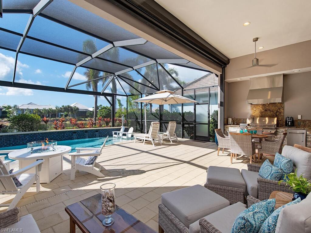 6445 Pembroke Way Naples, FL 34113 - Photo 20 of 40 a view of a terrace with furniture and umbrella