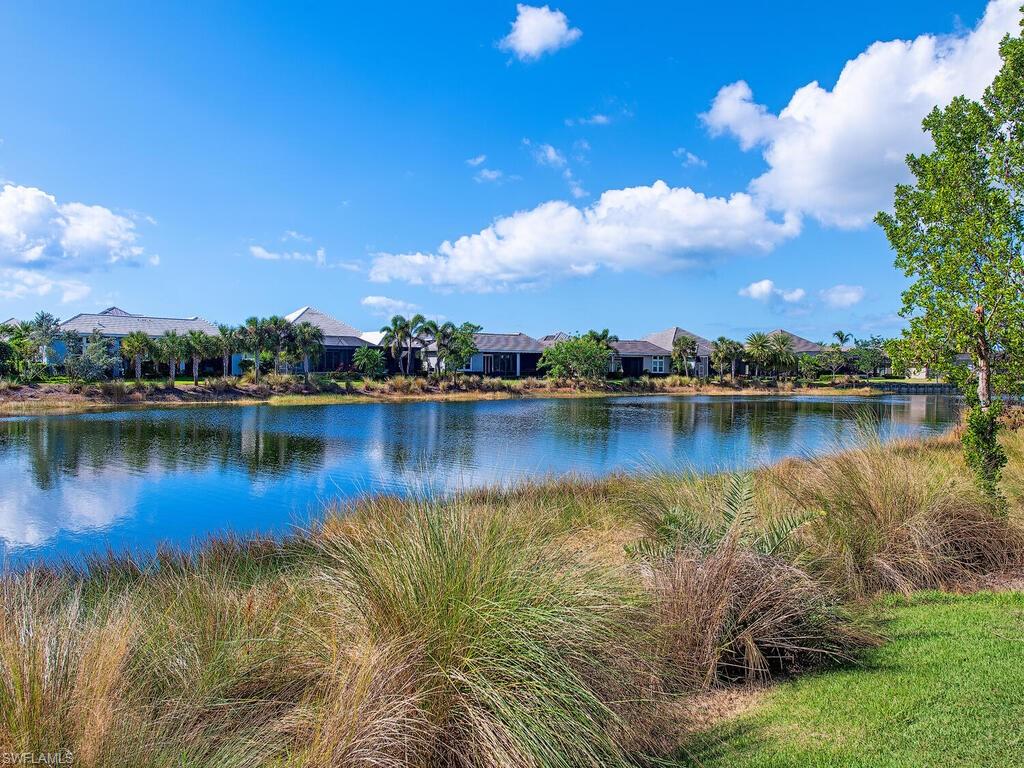 6445 Pembroke Way Naples, FL 34113 - Photo 25 of 40 a view of a lake with houses in the back