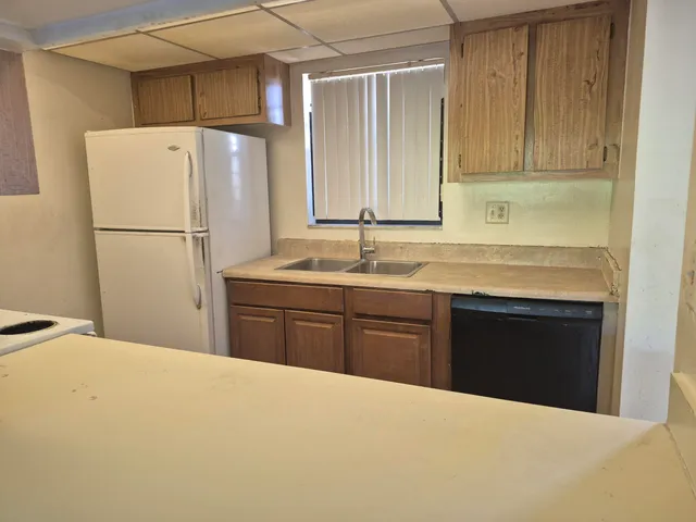 a kitchen with a refrigerator sink and cabinets