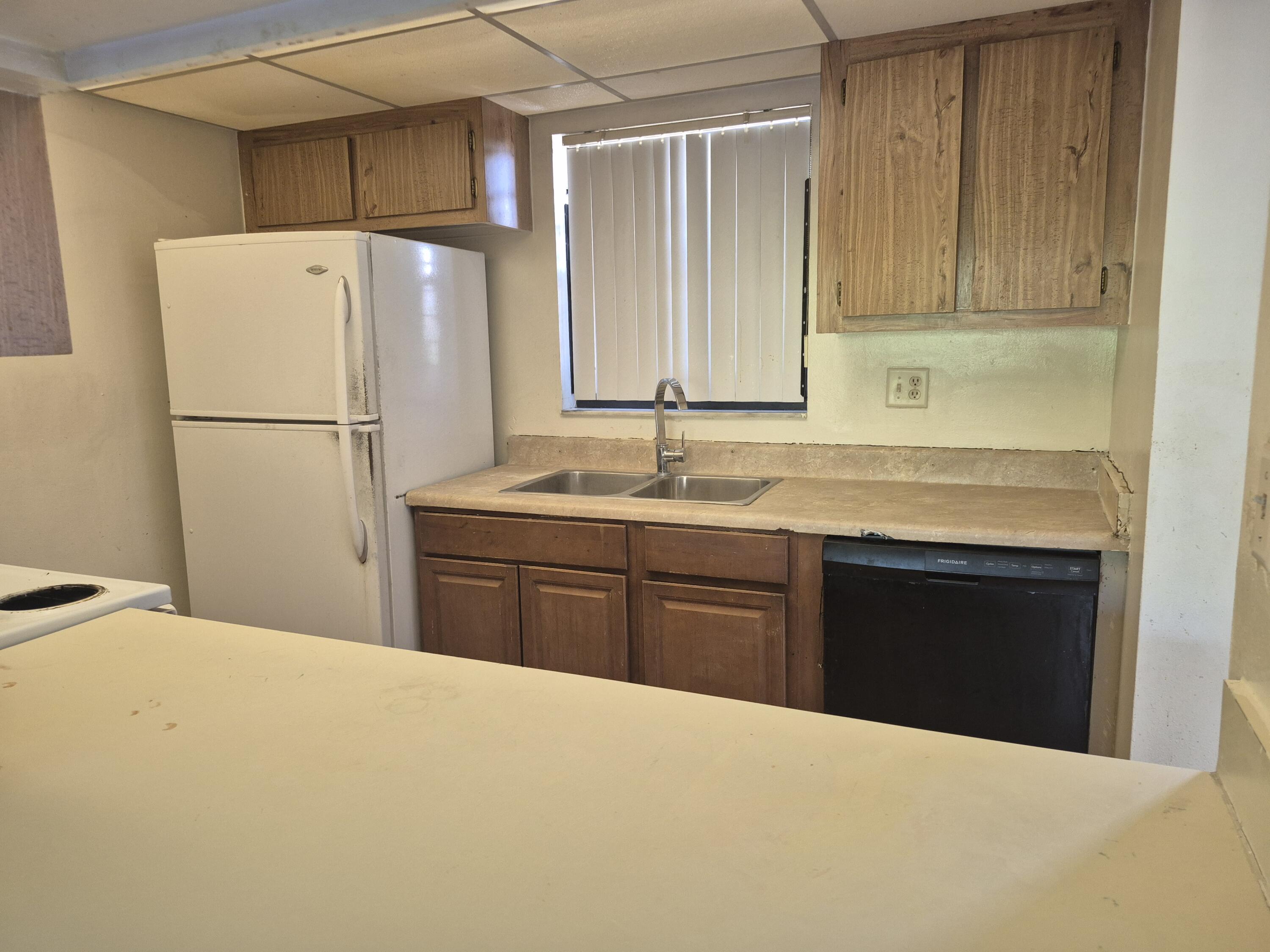 a kitchen with a refrigerator sink and cabinets