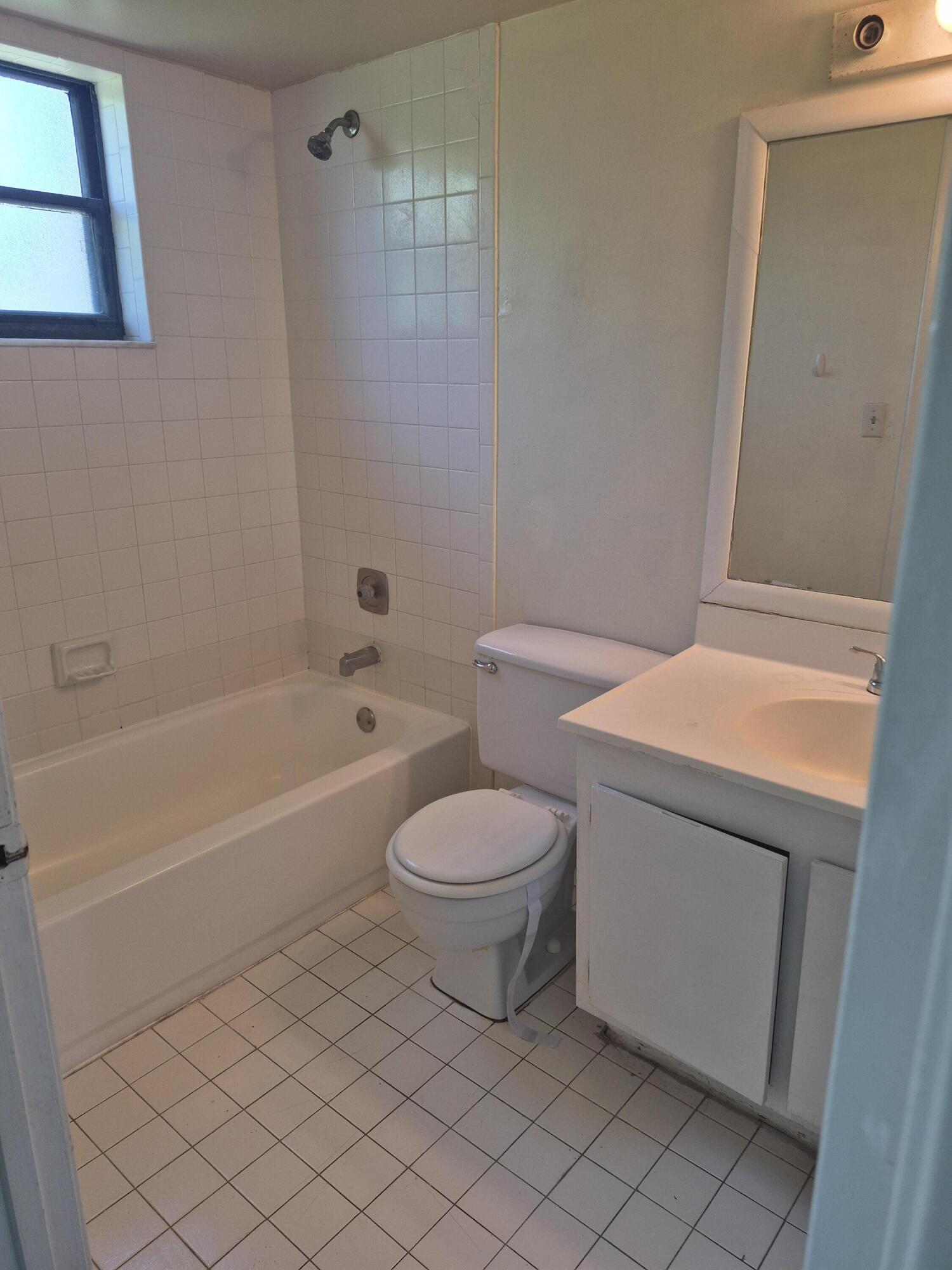 2050 North Congress Avenue, Unit 407 West Palm Beach, FL 33401 - Photo 7 of 16 a bathroom with a toilet a sink and bathtub
