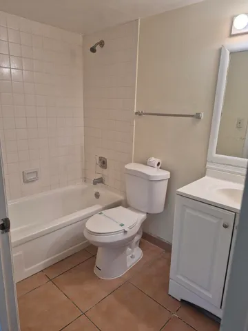 a white toilet sitting next to a bath tub
